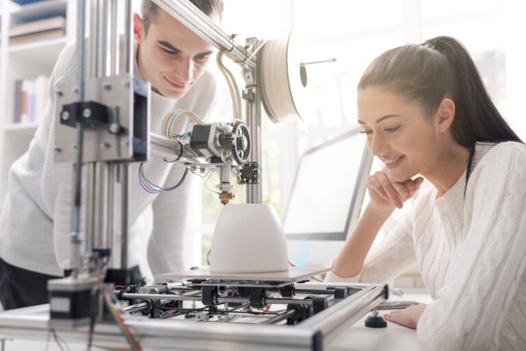 Engineering students using a 3D printer in the lab