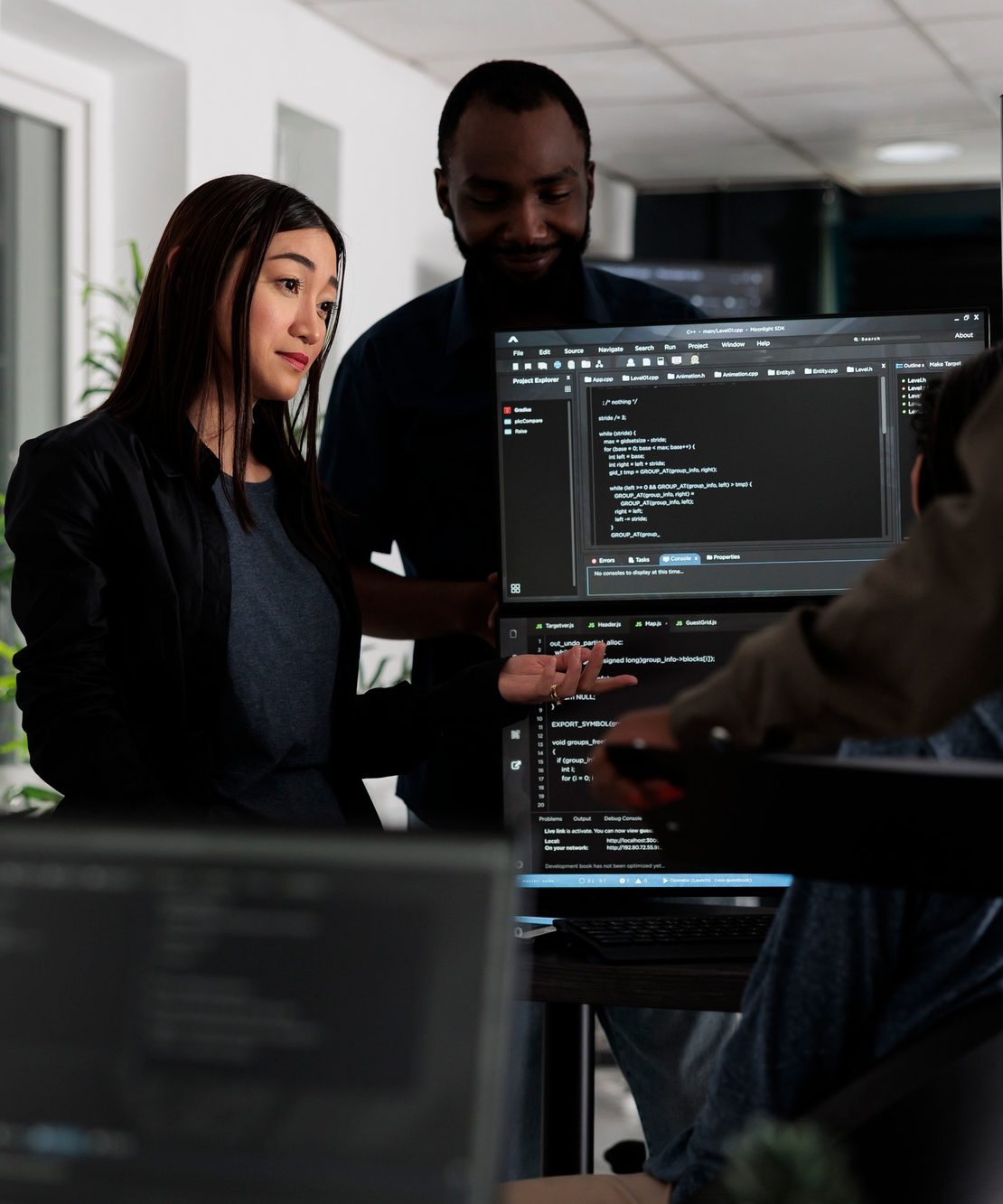 Multi ethnic programmers checking source code and database