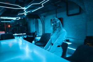 Young woman in neon glasses in futuristic style.